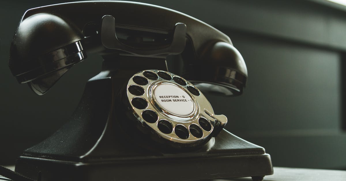 UK visa hotel booking and contact information - Black Rotary Telephone on White Surface