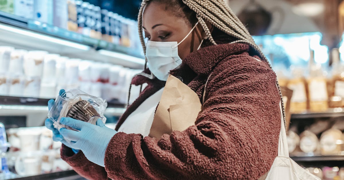 UK Visa refused twice for GMC ID check [duplicate] - Black female shopper reading label on food in supermarket