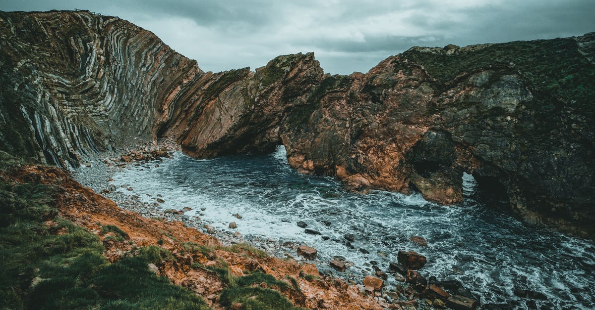 UK visa with overstay background in Schengen - Brown and Black Rock  Formation on Water