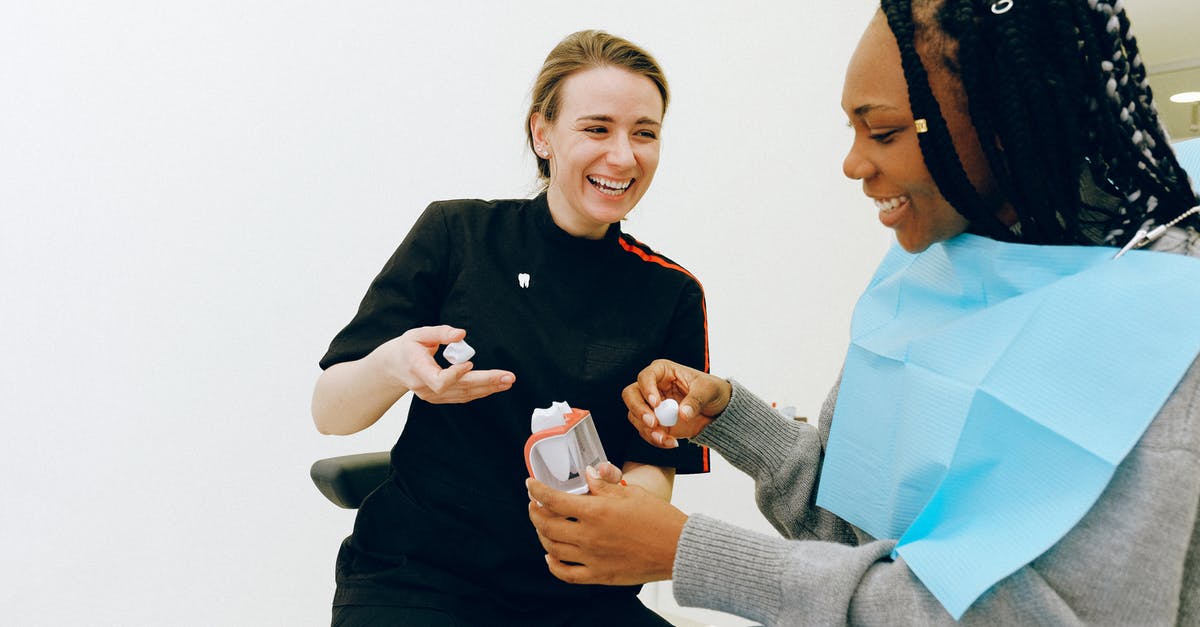 UK Visit Visa Guidance - Amount to show in Bank Statement - Cheerful young female dentist discussing tooth structure with client