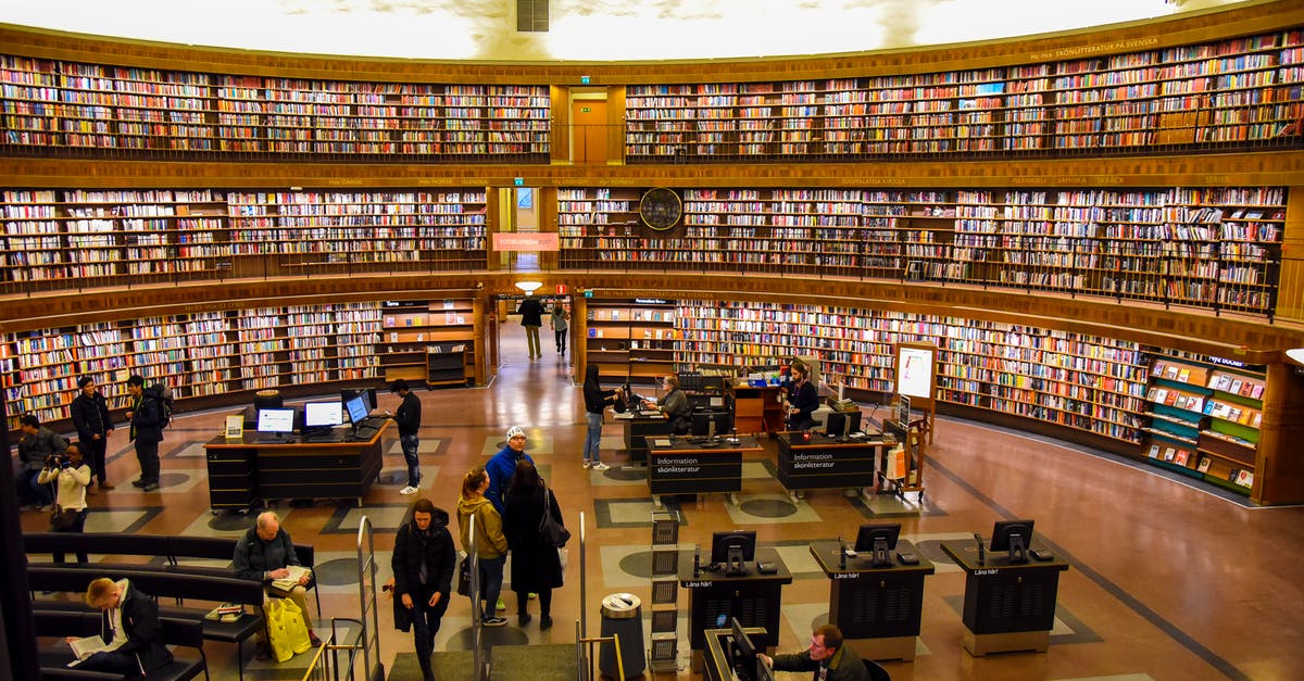 UK Visitor visa - arriving together - Unrecognizable visitors in public library with literature collection