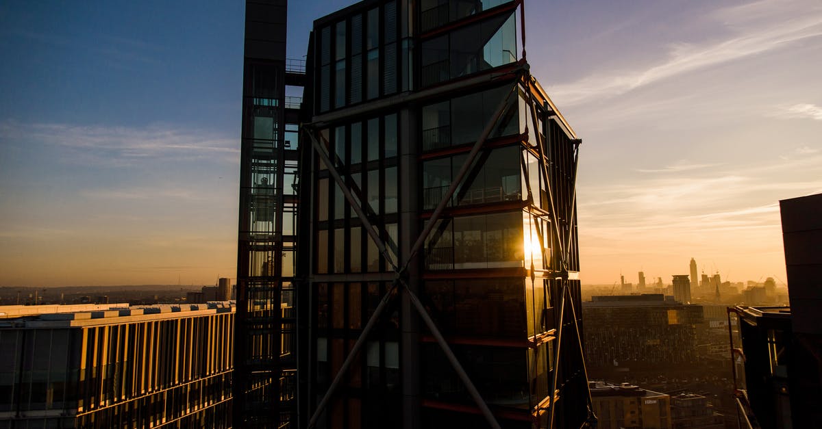 UK visitor visa without any property - Exterior of contemporary glass skyscraper against sundown sky in city