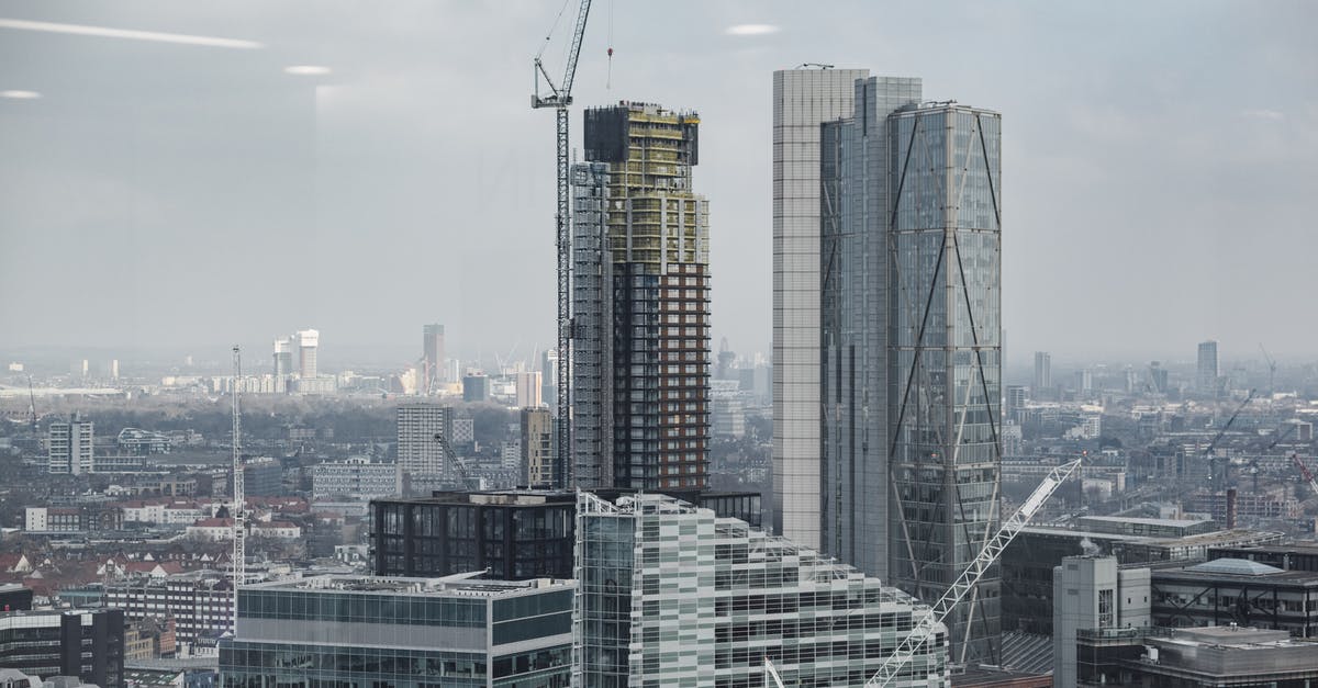 UK visitor visa without any property - Complex of modern multistory buildings and commercial skyscrapers with tower cranes under cloudy sky in London