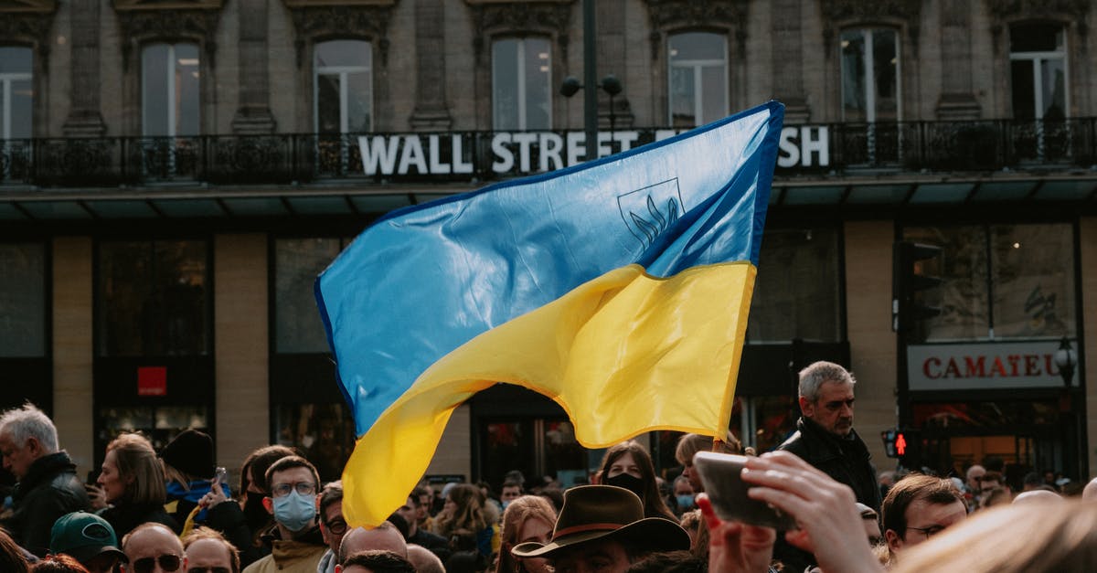 Ukrainian biometric passports - Blue and yellow Ukrainian Flag Waving Above Crowd of People