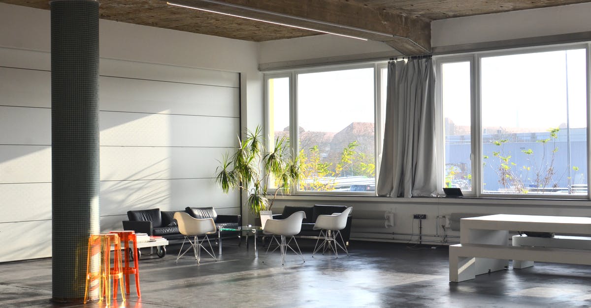 Unbookable column of seats on 777-200 - Interior of modern spacious room with column and couches placed near big window with curtains near table in light studio