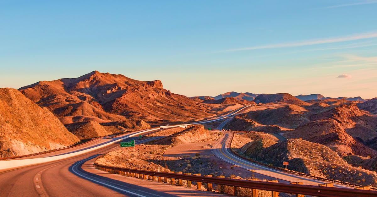 Unlimited Greyhound or Amtrak trips in US/Canada? - Empty asphalt road going through cactus fields towards rocky mountains against cloudy blue sky in United States of America