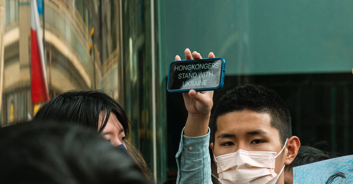 Upcoming stopover at Hong Kong what to do about the protests? - A Person Holding a Smartphone with a Support Message for Ukraine