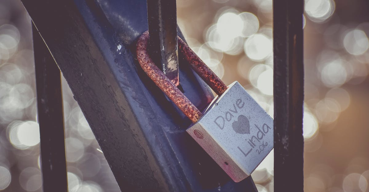 Updated Surname in Passport, Schengen visa has old name - Old lock hanging on metal fence