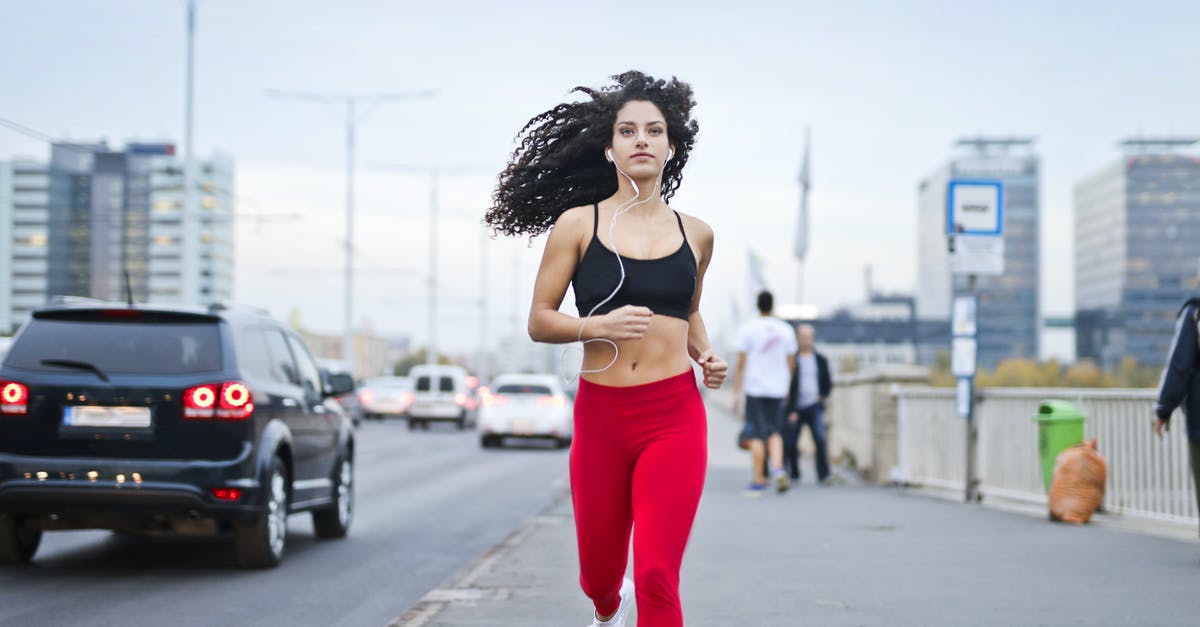 U.S. Health Insurance for road warriors - Photo of Woman Listening to Music on Earphones Running Down a Sidewalk