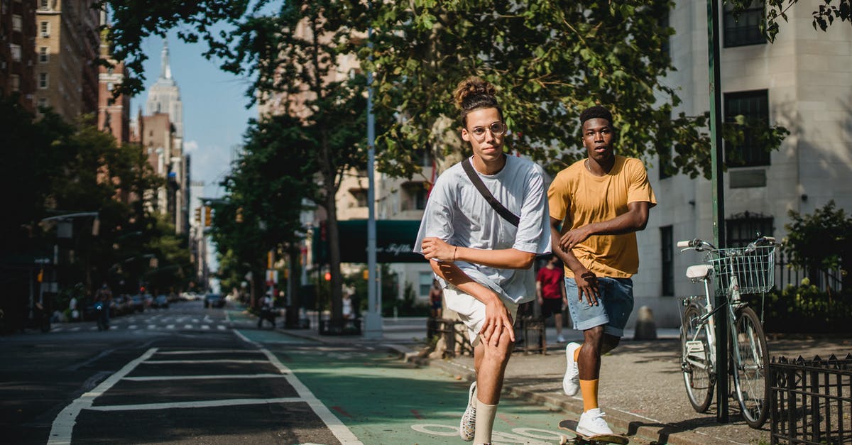 US Preclearance time at Abu Dhabi - (AUH - MAN - ORD) - Full body of trendy active multiethnic male teens in stylish outfits balancing on skateboards during outdoor training in New York