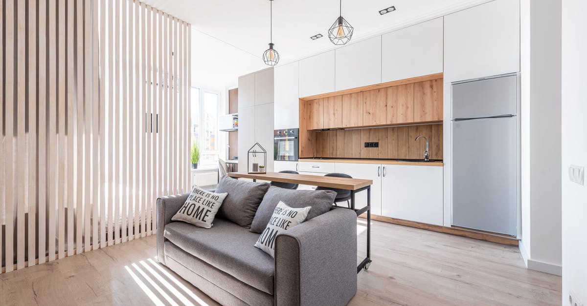 USA: cellular plans with domestic roaming - Interior of contemporary open plan kitchen with white cabinets and cozy sofa with cushions in sunlight