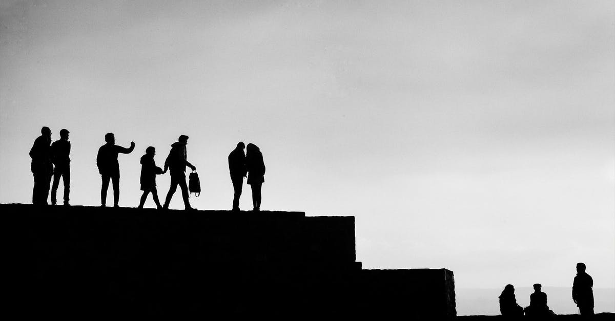 US-Canada border at Blaine-White Rock - Black and white of group of people resting on stone border and enjoying picturesque view