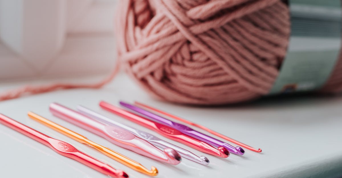 Use a different passport for your home country [closed] - Closeup of row of multicolored crochet needles and ball of beige threads for knitting in bright room