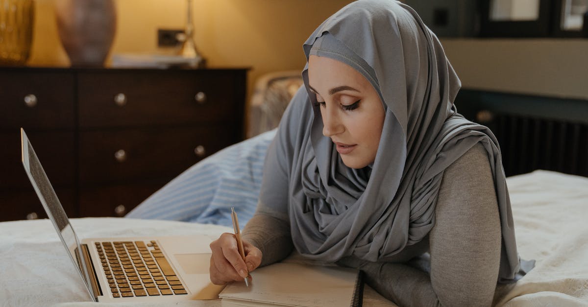 Using 1,000 CHF notes in Switzerland - Woman in Gray Hijab Using Macbook Air