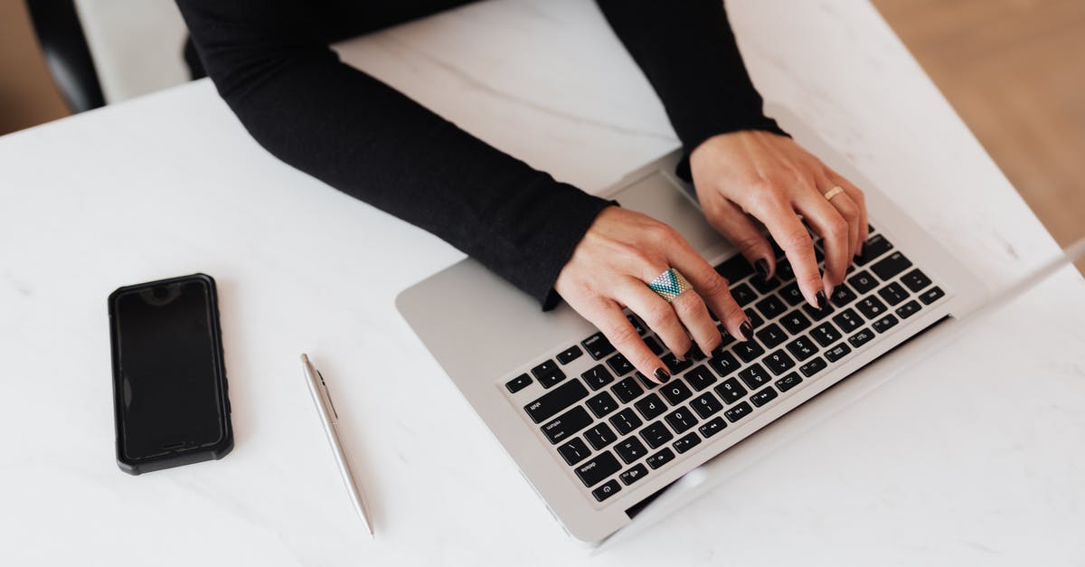 Using a data mobile wi-fi device abroad (UK to Spain) [closed] - From above of crop anonymous young female programmer typing on netbook keyboard while sitting at table with smartphone in modern workspace