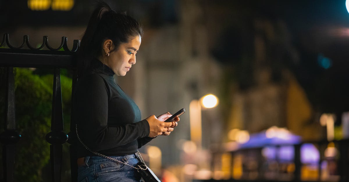 Using a quad-band phone in Japan? - Woman Using Phone on a Street at Night