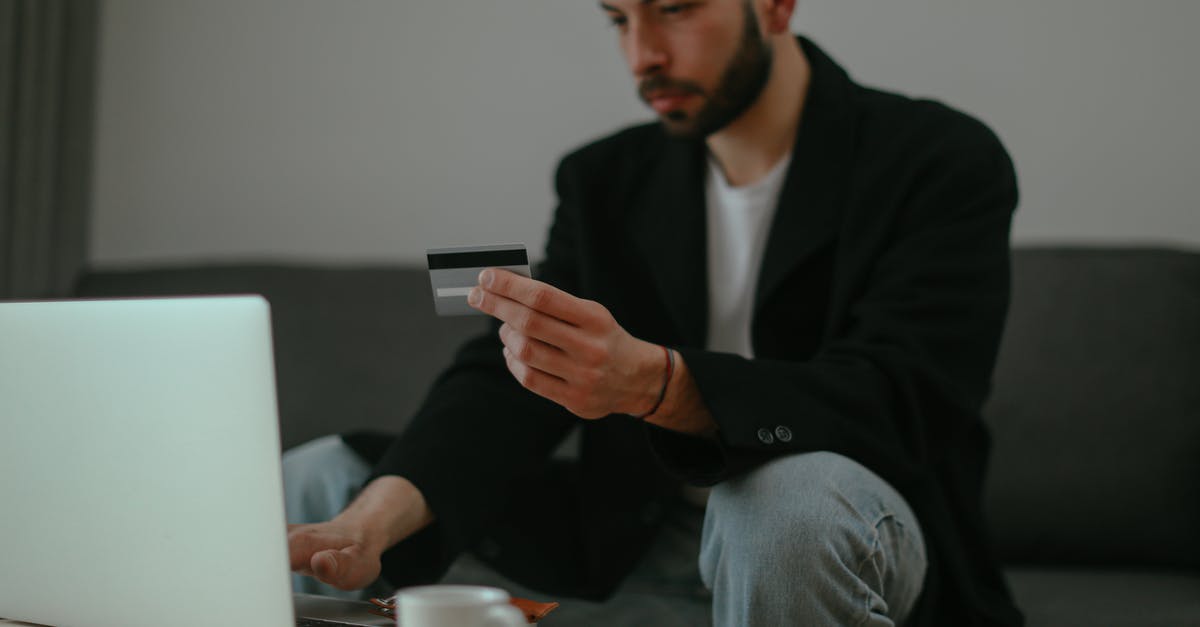 Using a Suica card on Hiroshima trams and ferry line - Man in Black Sweater Holding Smartphone