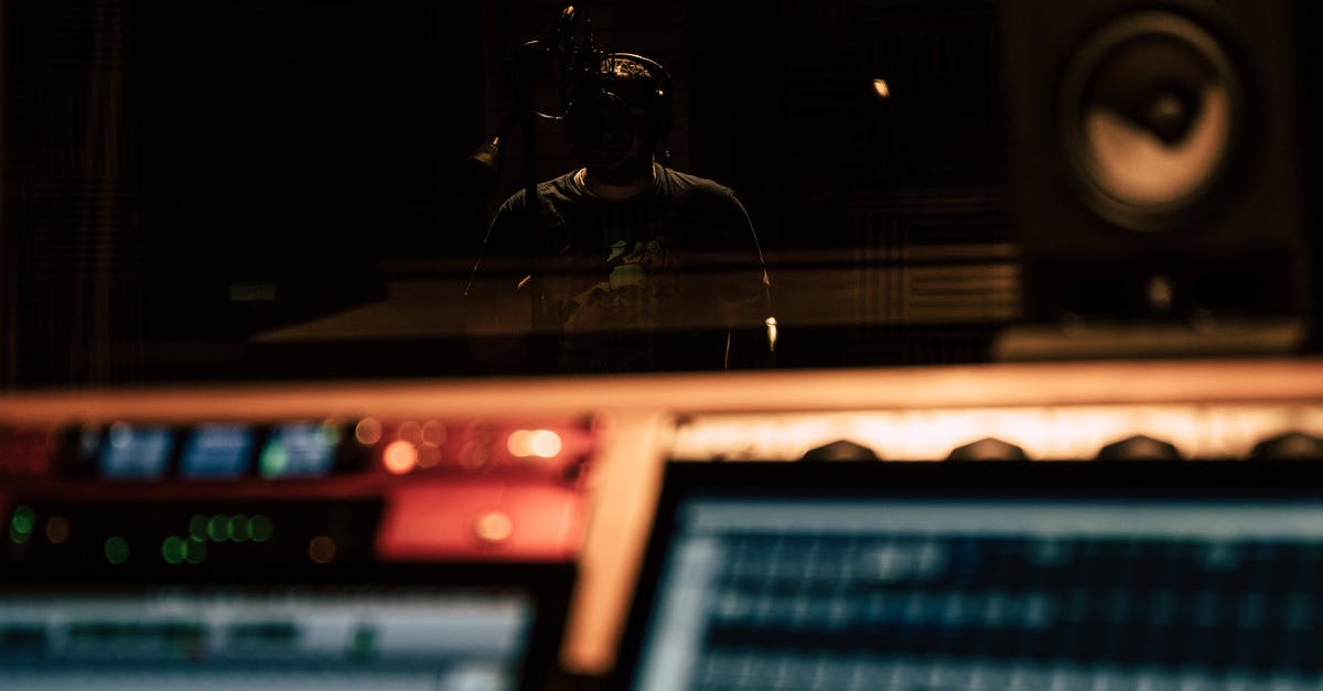 Using airline headphones with own equipment (during a flight) - Man recording song in music studio