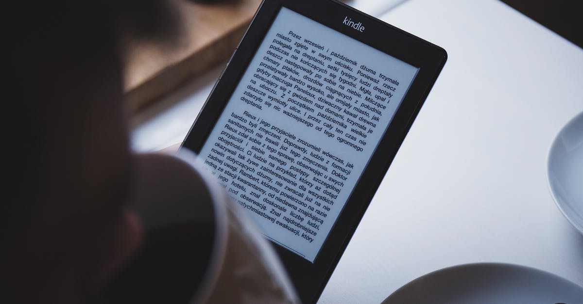 Using an Amazon Kindle onboard a flight? - Person Using E-book Reader While Drinking Coffee