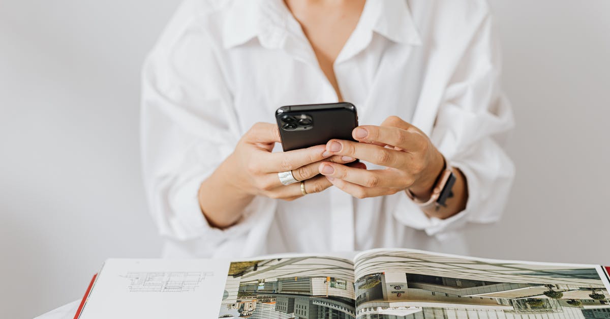 Using an iPhone 4S in South Korea - Person in a White Shirt Using a Black Cell Phone