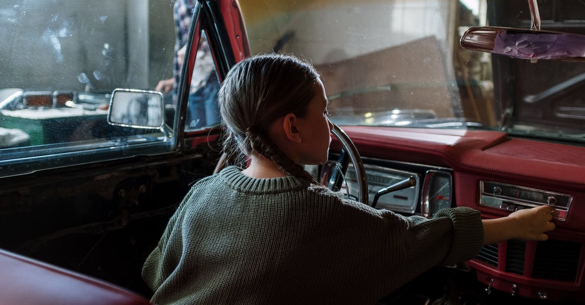 Using child car seats in Cuba? - Woman in White and Black Sweater Sitting Inside Car