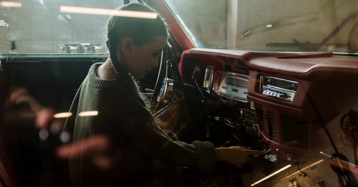 Using child car seats in Cuba? - Man in Black and White Striped Long Sleeve Shirt Sitting Beside Red Car