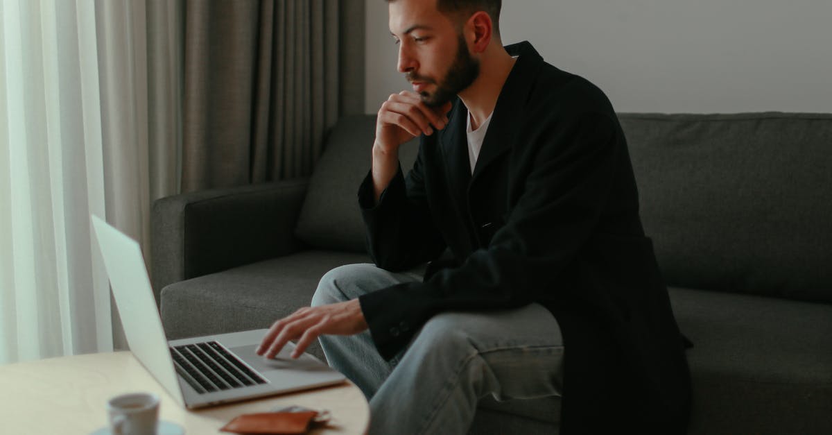 Using LG V10 or Motorola in Japan - Close-Up Shot of a Man Sitting on a Couch while Using a Laptop