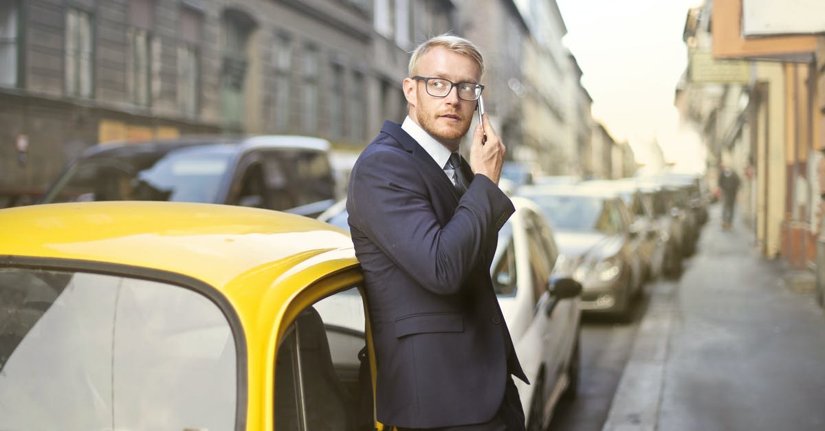 Using local transportation in Malta? - Man in Black Suit Jacket While Using Smartphone