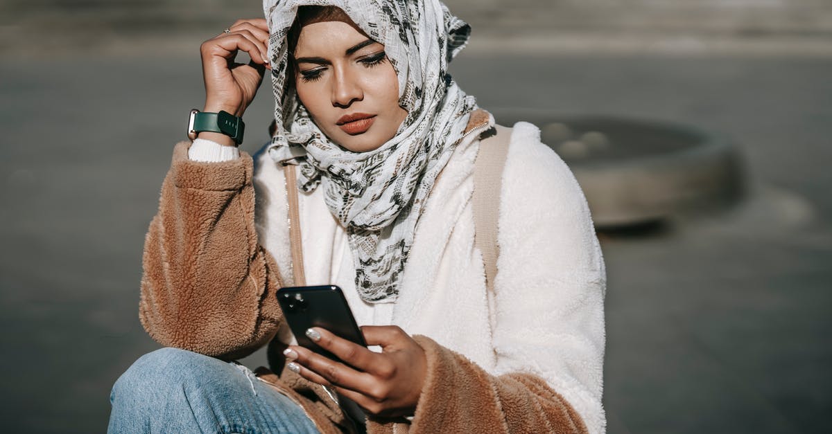 Using Modern Standard Arabic in Arabic-speaking countries - Stylish young ethnic lady in hijab using mobile phone on street