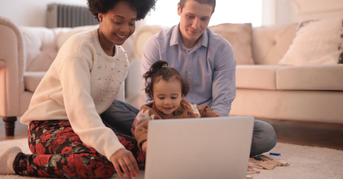 Using no-show ticket for infant - Photo of Family Sitting on Floor While Using Laptop