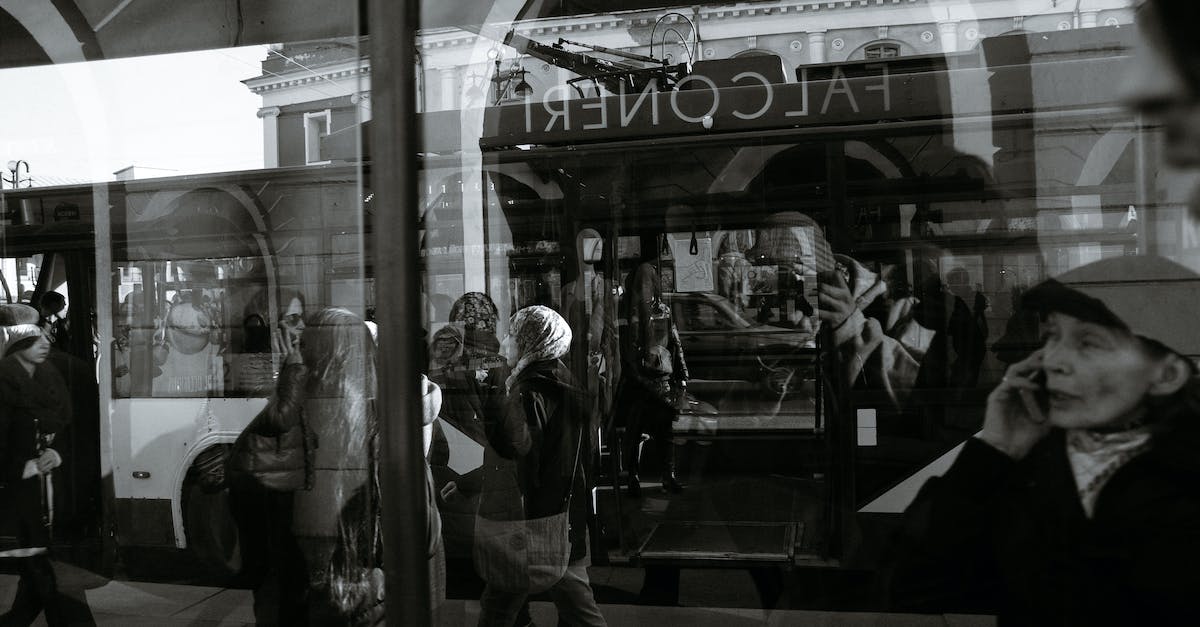 Using Occupy Wall Street as a travel hack - any downsides? - Black and white through glass wall view of anonymous passengers in trolleybus near sidewalk in town