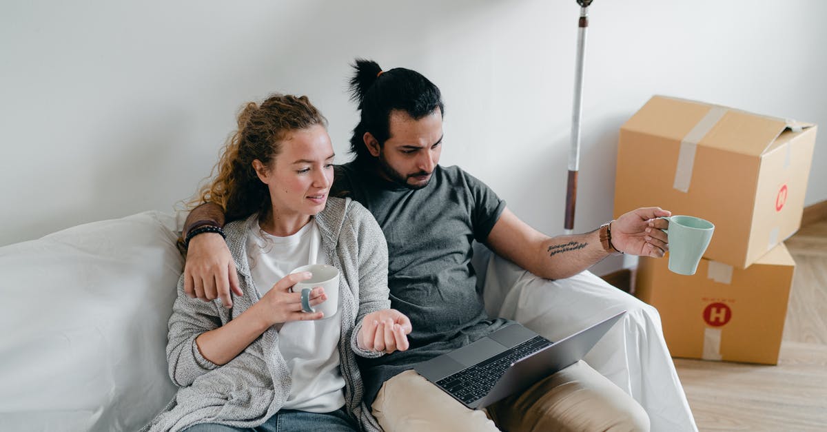 Using parent's property and will as evidence of assets - Bonding couple browsing laptop after packing carton boxes