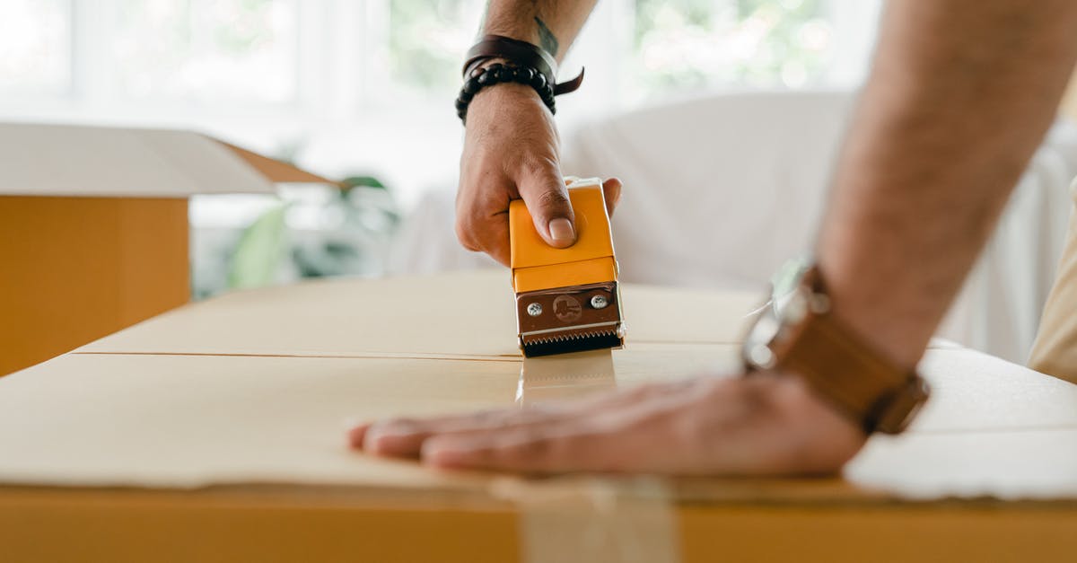 Using parent's property and will as evidence of assets - Crop man packing carton box with scotch tape dispenser