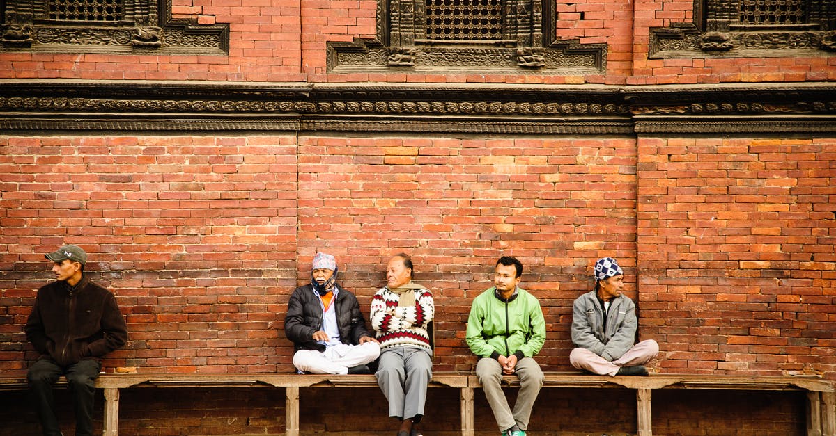 Vaccination for Nepal - 3 Men and 2 Women Sitting on Brown Wooden Bench