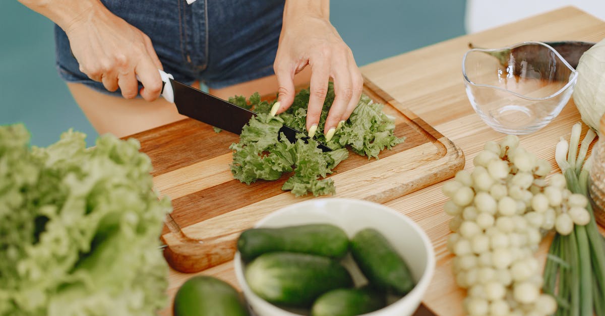 Vegetarian yatai food options in Fukuoka? - Person Slicing Green Vegetable on Brown Wooden Chopping Board