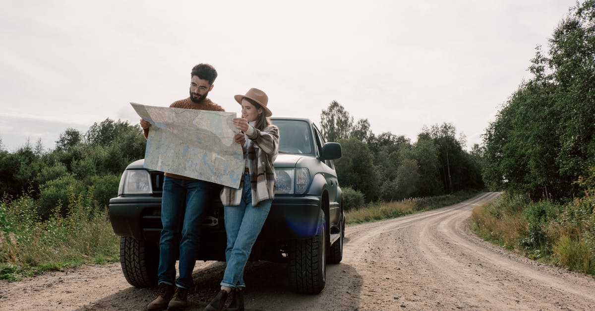 Vehicle customs, lost passport - A Couple on a Road Trip Looking at a Map 