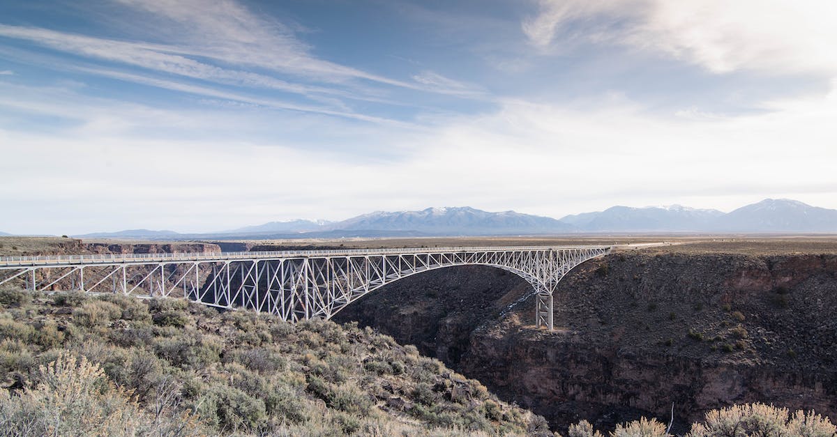 Via ferratas in Pyrenees - Landscape Photography of White Metal Bridge Under Blue Sky