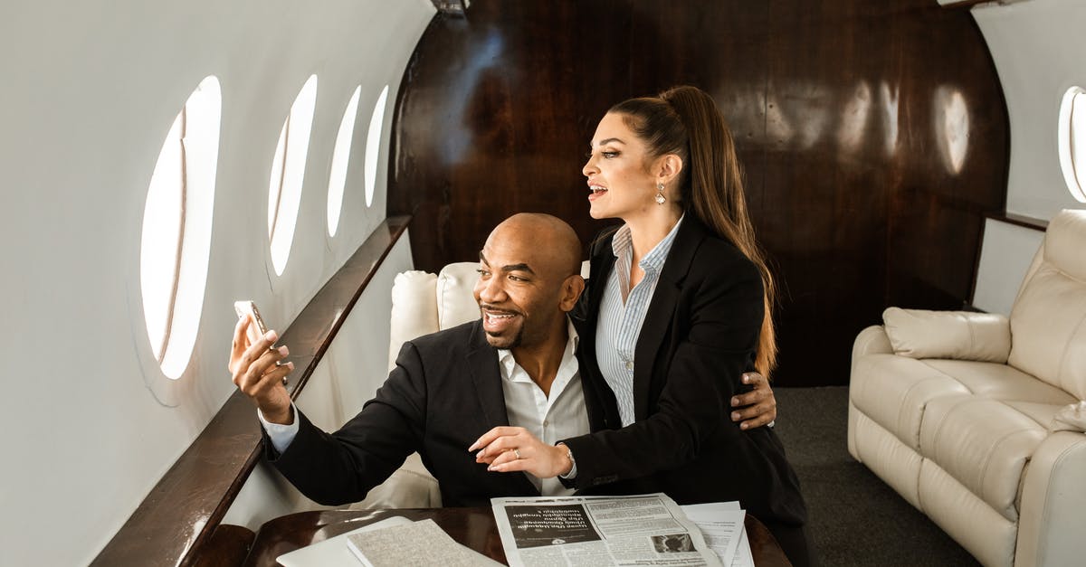 Viability of stacking passengers in an airplane cabin [closed] - Man in Black Suit Jacket Sitting Beside Woman in White Dress Shirt