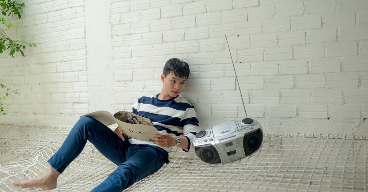 Vietnam e-visa photo requirements - Boy Sitting Near Radio Holding White Catalog