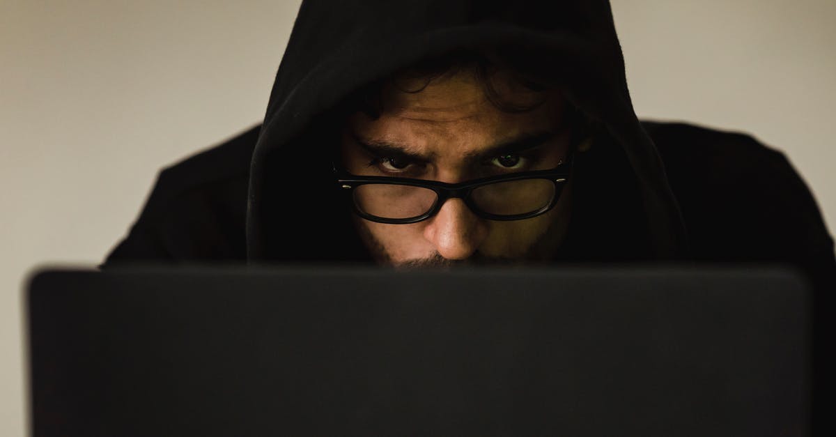 Violation of Schengenvisum terms? [closed] - Serious young male programmer wearing black hoodie browsing netbook and hacking software in studio