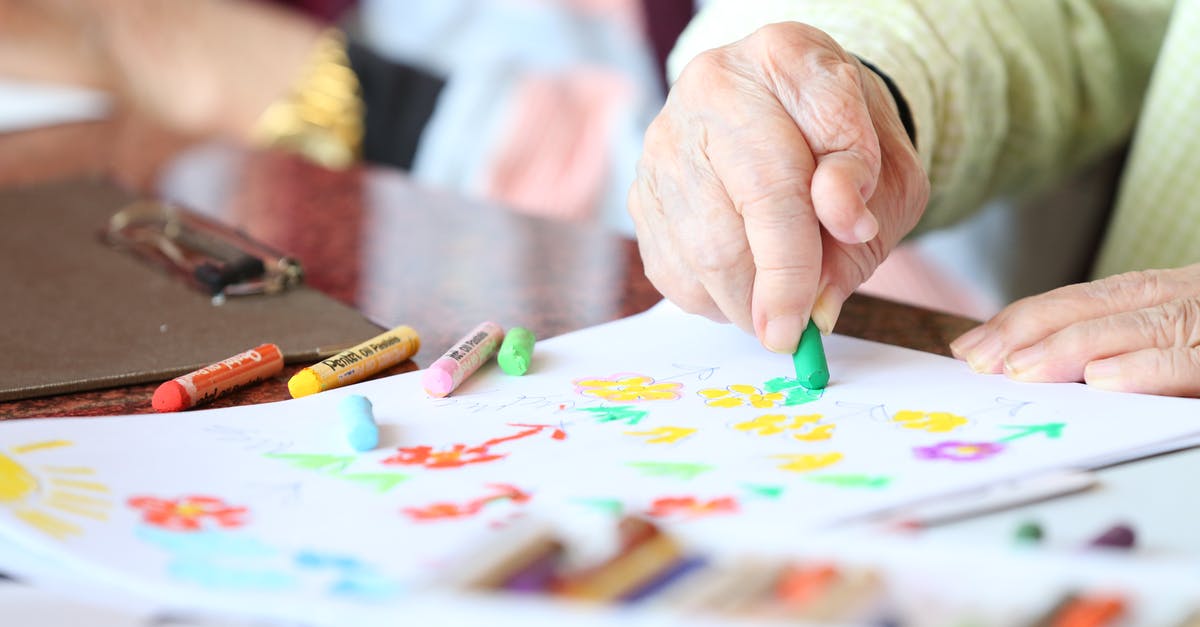 Visa Documentation to support 'Intent to Return Home' as a retired person - Faceless senior patient with arthritis drawing with yellow crayon at table in rest home Visa Documentation to support 'Intent to Return Home' as a retired person - Faceless senior patient with arthritis drawing with yellow crayon at table in rest home