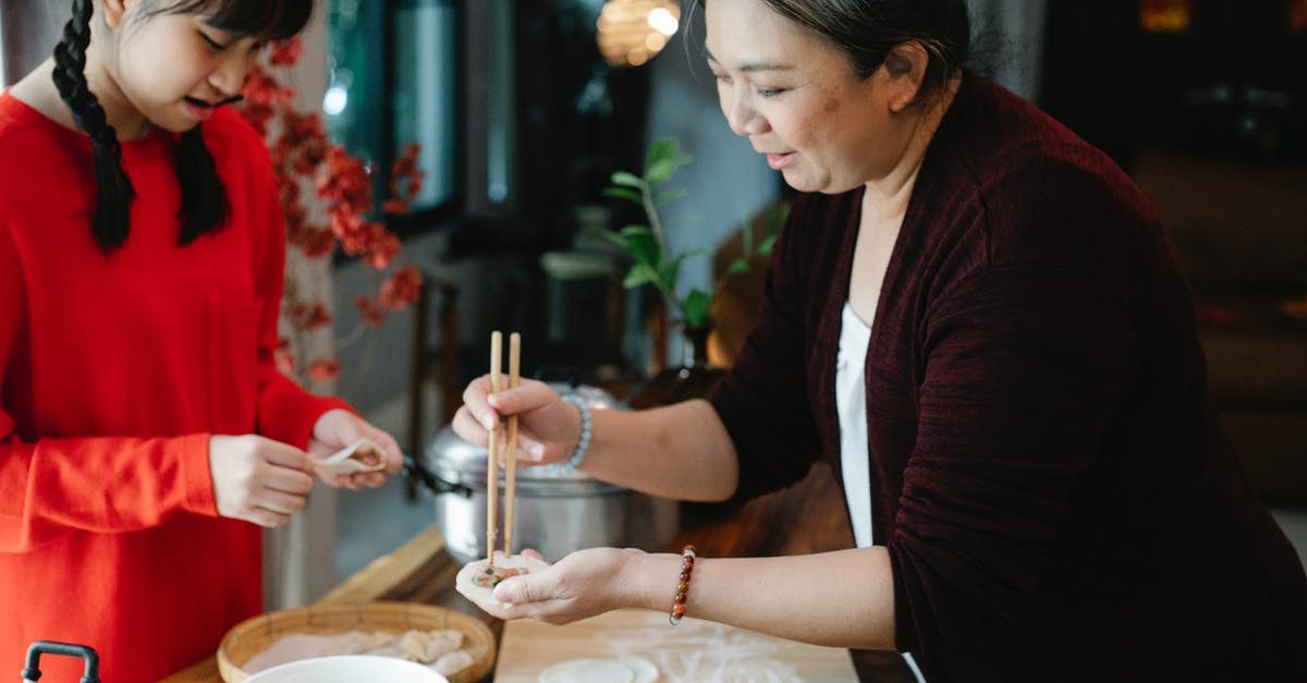 Visa etc. for Chinese grandmother to re-visit the US? - Crop teenage Asian girl with dark hair helping grandmother to fold traditional Chinese jiaozi dumplings while cooking together in kitchen