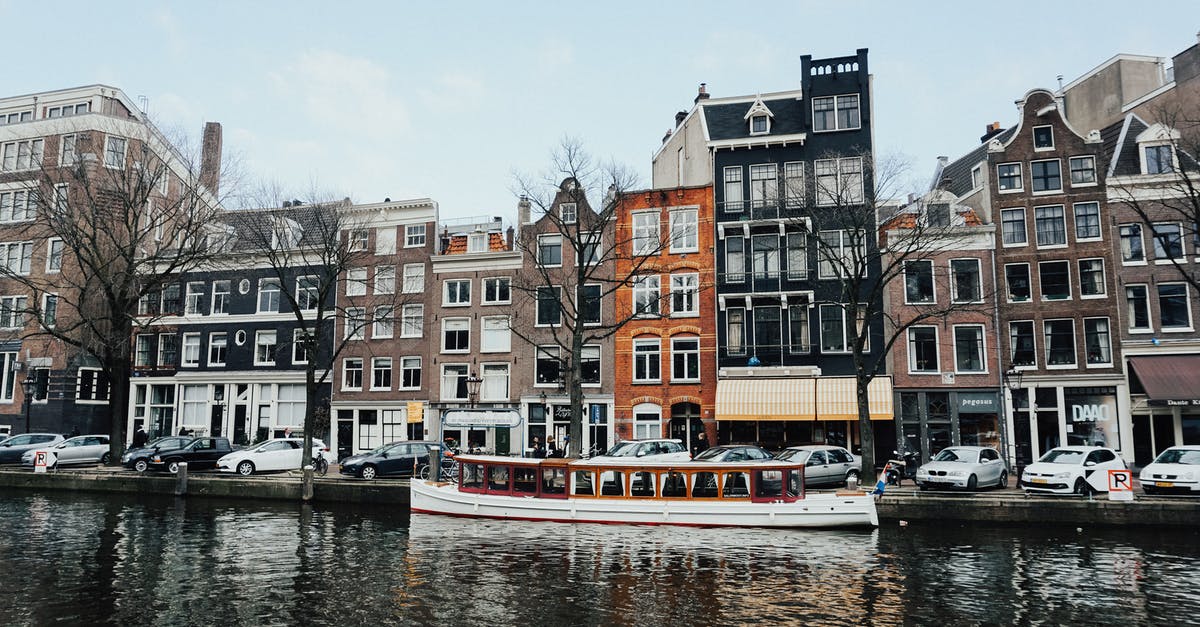 Visa for Amsterdam - White And Brown Wooden Boat On Body Of Water