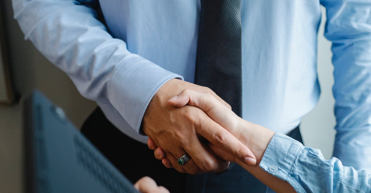 Visa for Belgium visit as well as business meeting [closed] - High angle of crop unrecognizable male and female business partners in formal clothes shaking hands after successful deal