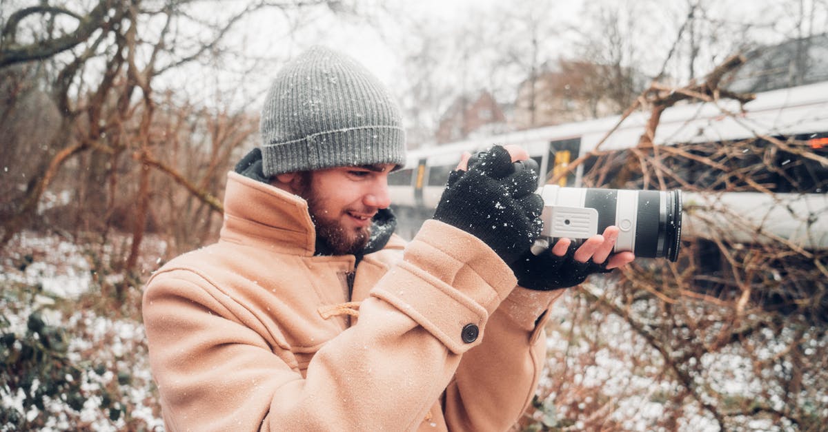 Visa options to hold seminars in the UK - Man in Brown Coat Holding Camera