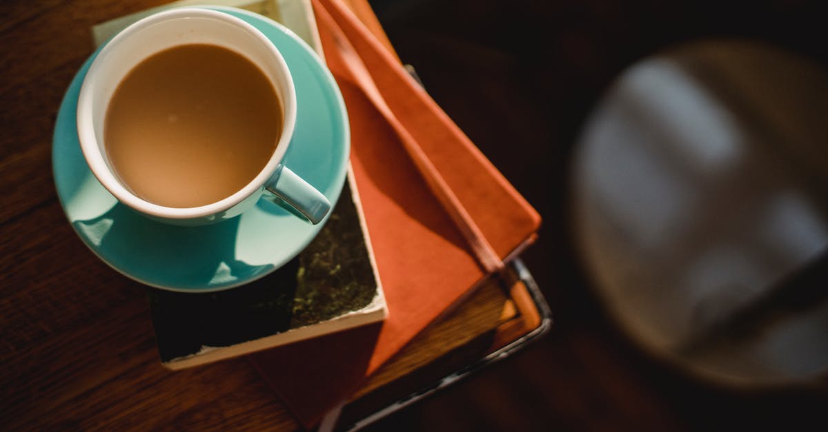 Visa requirement with a residence permit from Greece - From above of ceramic cup of hot aromatic coffee placed on book and notepad