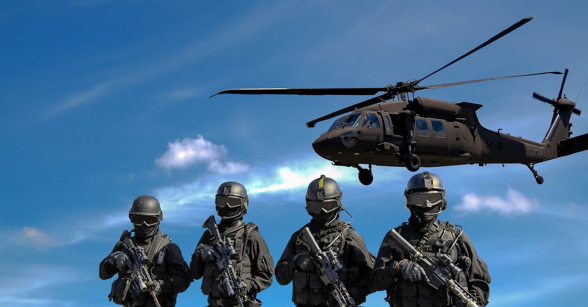 Visa services in time of War - Four Soldiers Carrying Rifles Near Helicopter Under Blue Sky