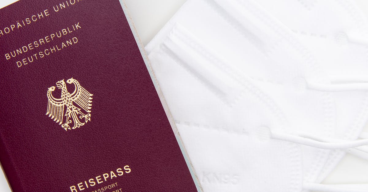 Visa to Germany with Titre De Voyage document - Red and Gold Passport on White Textile
