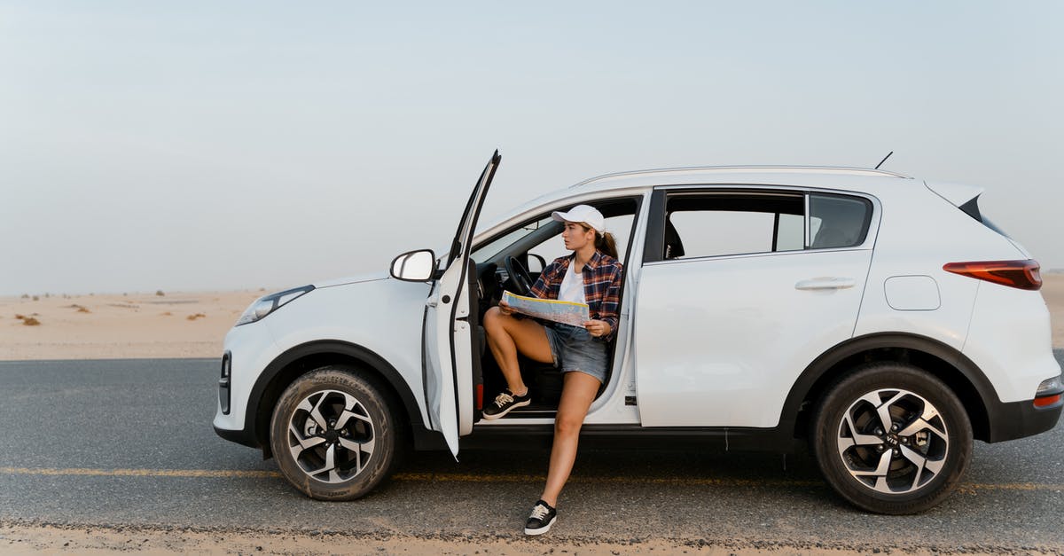 Visa to Oman travelling with a car from UAE - Woman Holding a Map While Inside a White Car