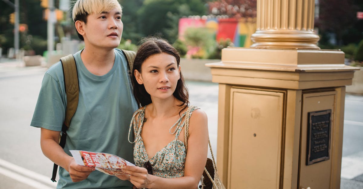 Visit the Norwegian fjords or other attractions when landing in Haugesund - Cheerful Asian couple with map navigating in city Visit the Norwegian fjords or other attractions when landing in Haugesund - Cheerful Asian couple with map navigating in city